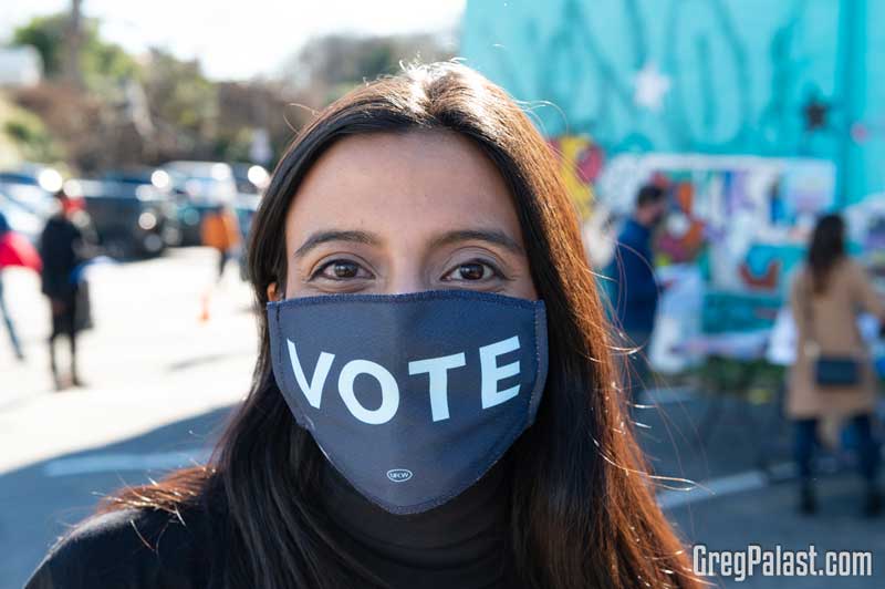 Democratic Voter wearing a face mask that says vote.